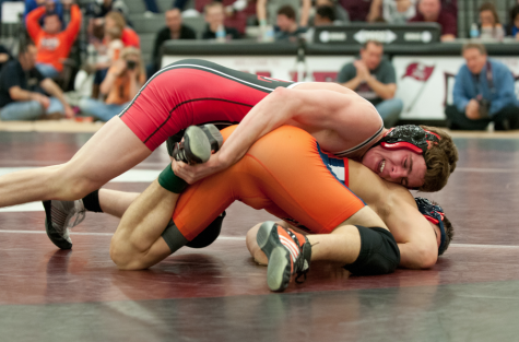 Alumni Aaron Otiker takes down his opponent in a 2013 wrestling match. 