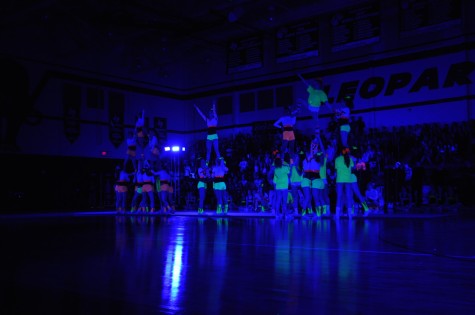 Cheerleaders perform the stunting part of their routine during the Black Light Pep Rally Friday, April 11, 2014.